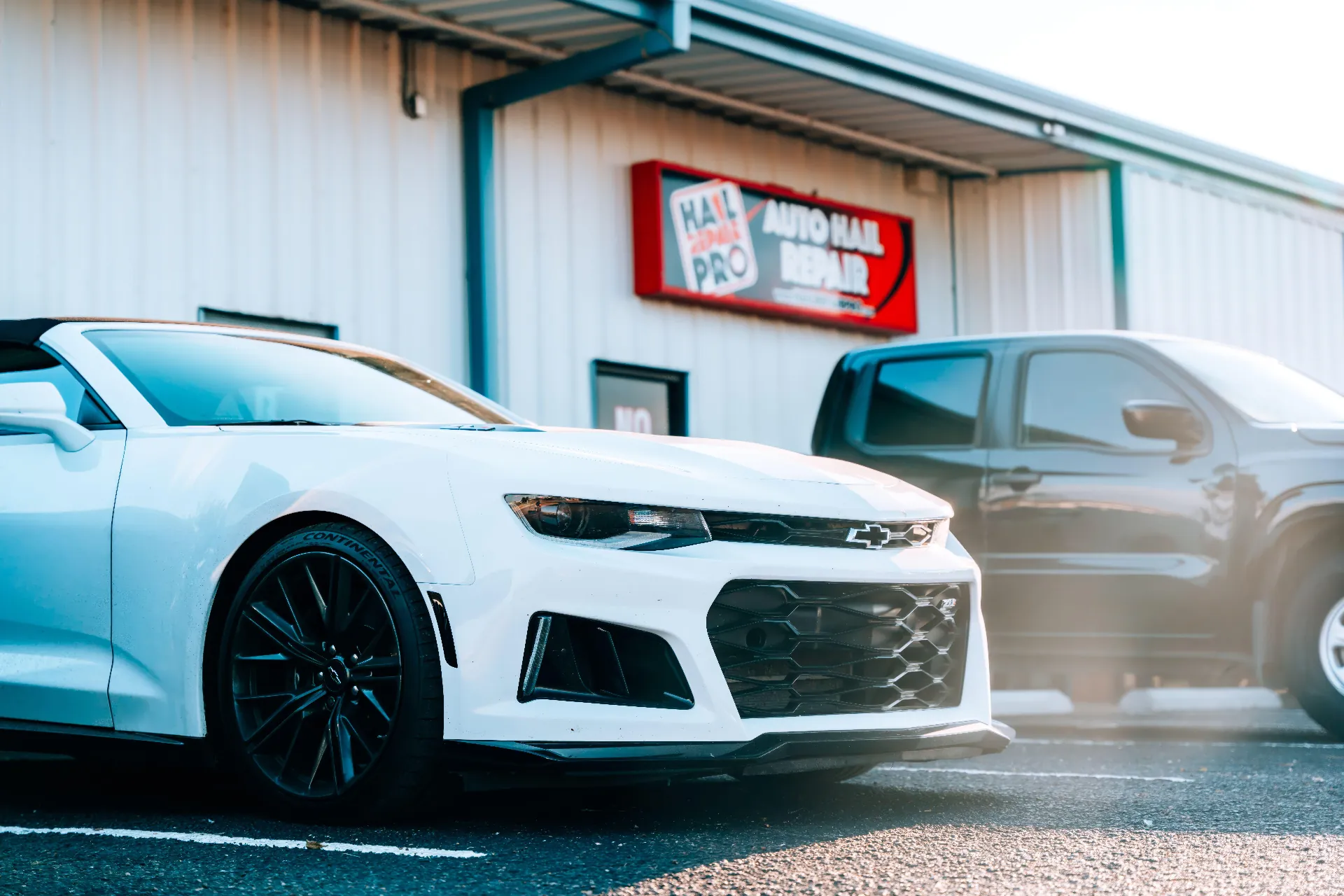 Hail Repair Pro Lubbock TX — Auto Hail Repair & Paintless Dent Repair Shop at 6007 43rd St Ste A | (806) 724-6100 White Chevrolet Camaro ZL1 convertible parked outside Hail Repair Pro Lubbock TX storefront at 6007 43rd St Ste A — local Auto Hail Repair and Paintless Dent Repair shop covering your deductible up to $1,000, with Free Loaner Cars and Free Estimates